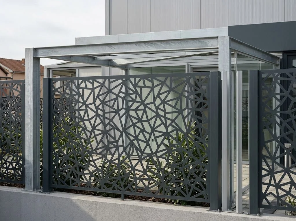 Decorative metal screens used as a partition in an outdoor space.